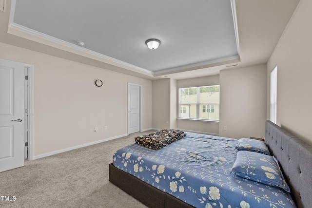 bedroom with a tray ceiling, carpet, and ornamental molding