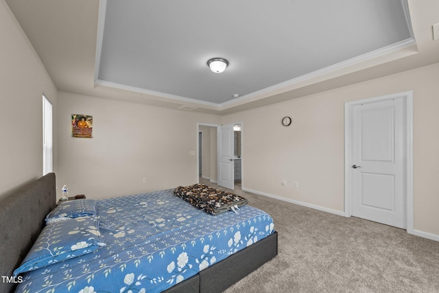 carpeted bedroom featuring ornamental molding and a tray ceiling