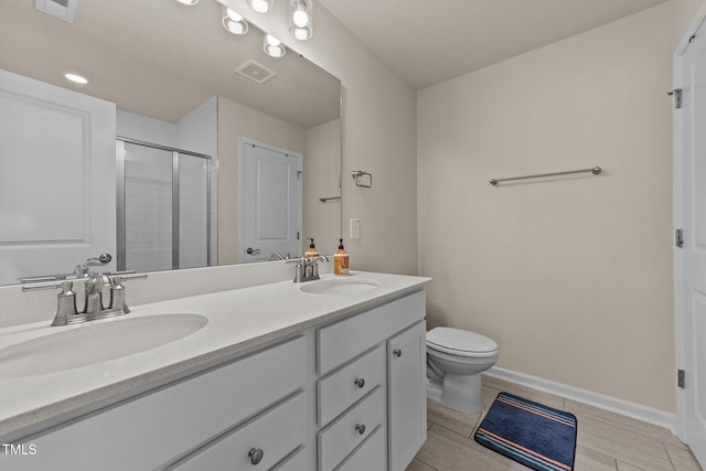 bathroom featuring vanity, hardwood / wood-style flooring, toilet, and a shower with shower door