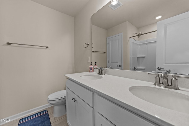 bathroom featuring walk in shower, vanity, and toilet