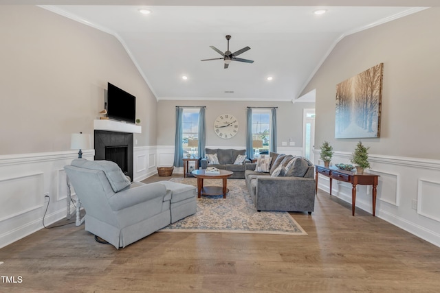 living room with ceiling fan, crown molding, light hardwood / wood-style floors, and lofted ceiling