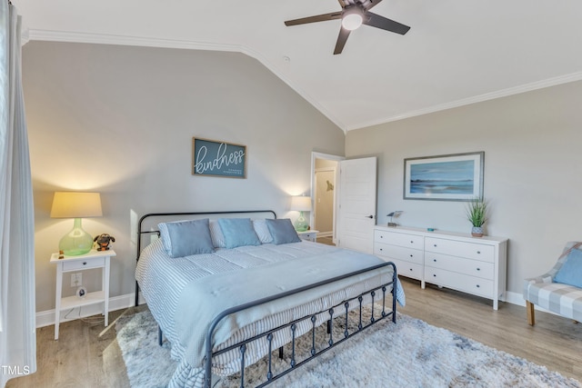 bedroom featuring ceiling fan, light hardwood / wood-style floors, ornamental molding, and vaulted ceiling