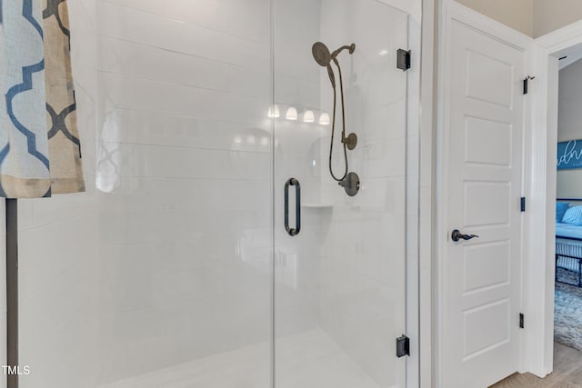 bathroom with an enclosed shower and hardwood / wood-style floors