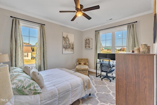 bedroom featuring ceiling fan, ornamental molding, and light hardwood / wood-style flooring