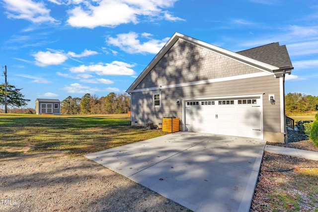 view of side of property with a yard, a shed, and a garage