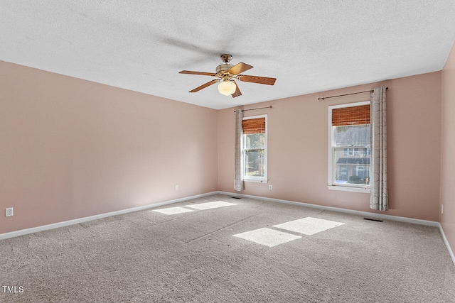 carpeted empty room with a textured ceiling and ceiling fan