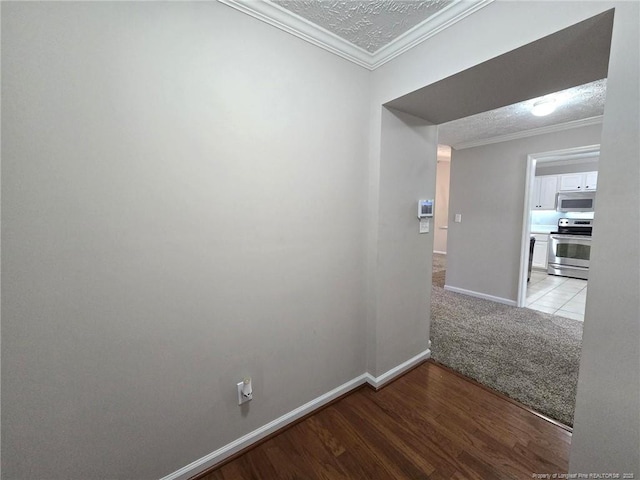 corridor with ornamental molding, light colored carpet, and a textured ceiling