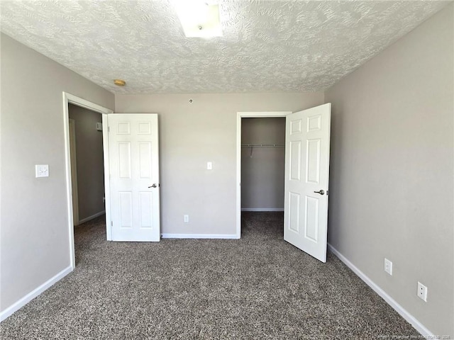 unfurnished bedroom featuring a closet, dark colored carpet, and a textured ceiling