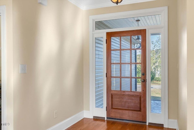 entryway with wood-type flooring and crown molding