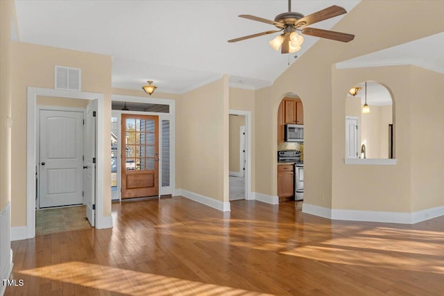 entrance foyer featuring ceiling fan, hardwood / wood-style floors, vaulted ceiling, and ornamental molding