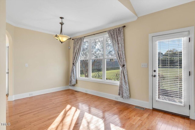 unfurnished dining area featuring light hardwood / wood-style flooring and crown molding