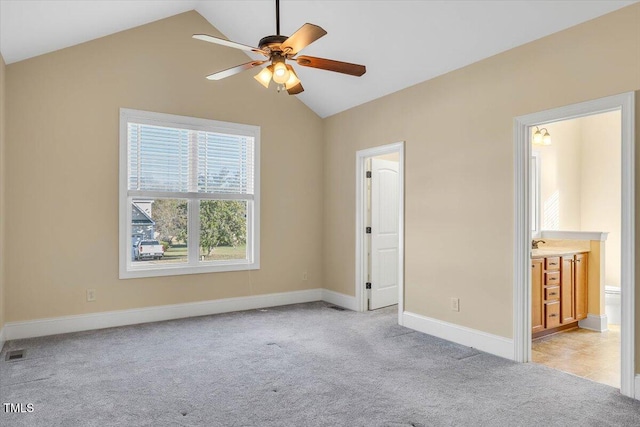 unfurnished bedroom with ensuite bathroom, ceiling fan, lofted ceiling, and light colored carpet