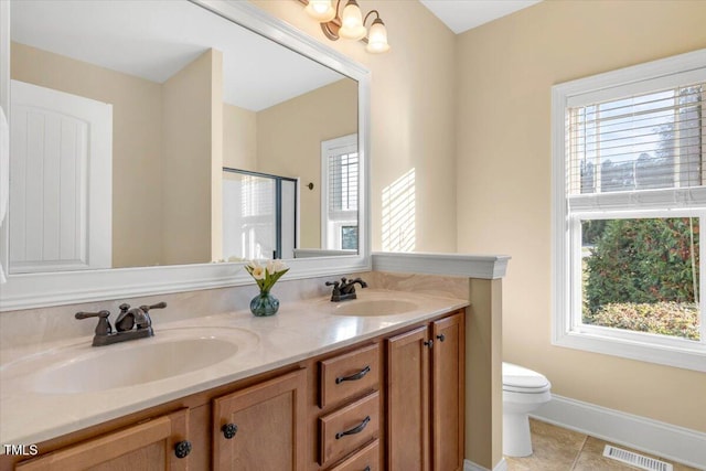 bathroom with tile patterned floors, vanity, toilet, and walk in shower