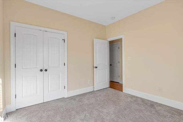 unfurnished bedroom featuring light colored carpet and a closet