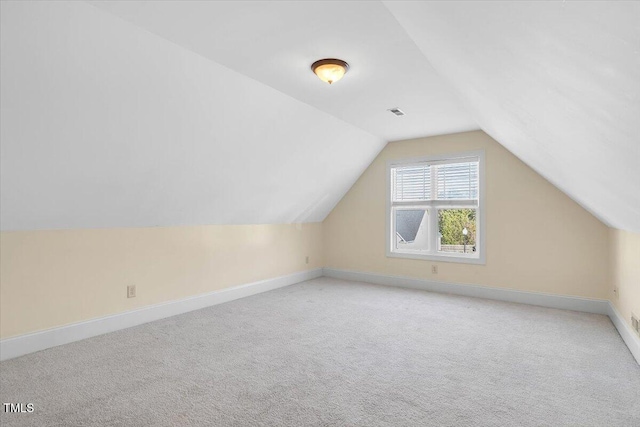 bonus room with light colored carpet and lofted ceiling