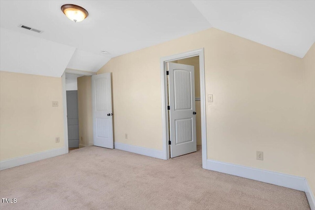 additional living space featuring lofted ceiling and light carpet