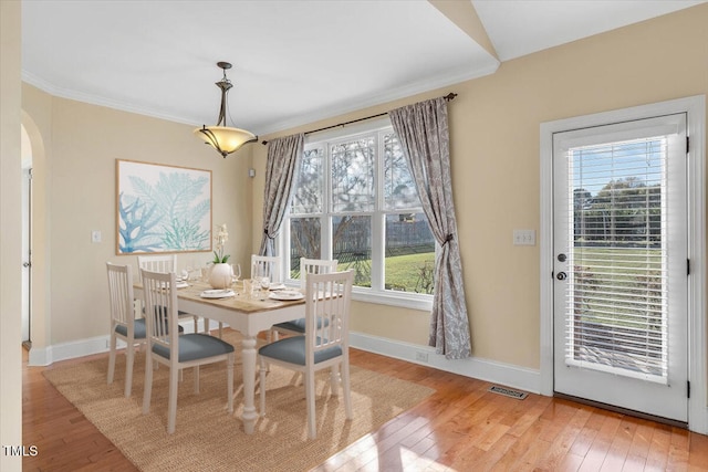 dining space with hardwood / wood-style floors and ornamental molding