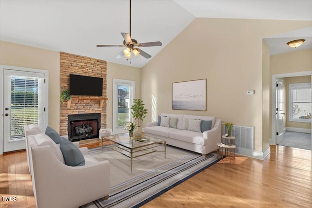 living room with a wealth of natural light, ceiling fan, high vaulted ceiling, and light wood-type flooring