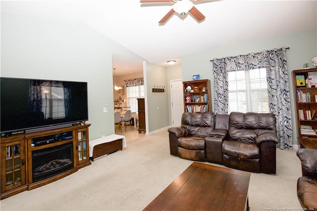 living room with lofted ceiling, carpet floors, and ceiling fan with notable chandelier