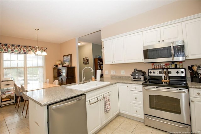 kitchen featuring kitchen peninsula, appliances with stainless steel finishes, sink, light tile patterned floors, and white cabinets