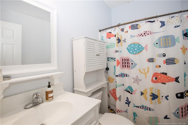 bathroom featuring a shower with shower curtain, vanity, and toilet