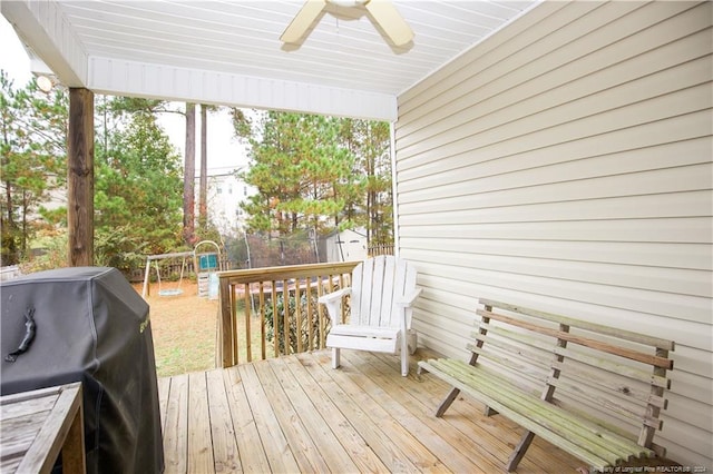 deck with a playground, a grill, ceiling fan, and a trampoline