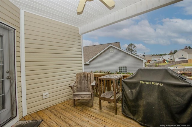 wooden terrace with ceiling fan and area for grilling