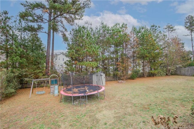 view of yard with a playground, a trampoline, and a storage unit