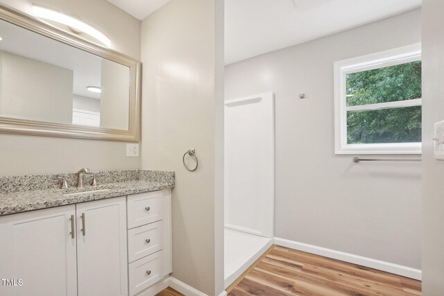 bathroom featuring walk in shower, wood-type flooring, and vanity