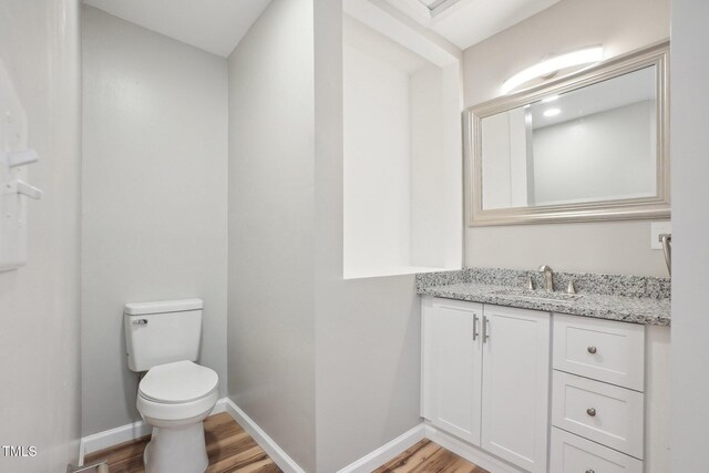 bathroom featuring hardwood / wood-style floors, vanity, and toilet