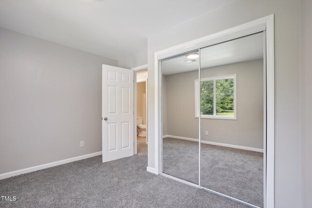 unfurnished bedroom featuring carpet floors and a closet