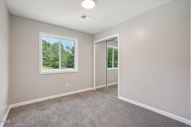 unfurnished bedroom with carpet floors and a closet