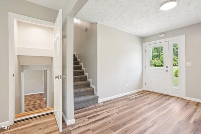 entrance foyer featuring light hardwood / wood-style floors and a textured ceiling