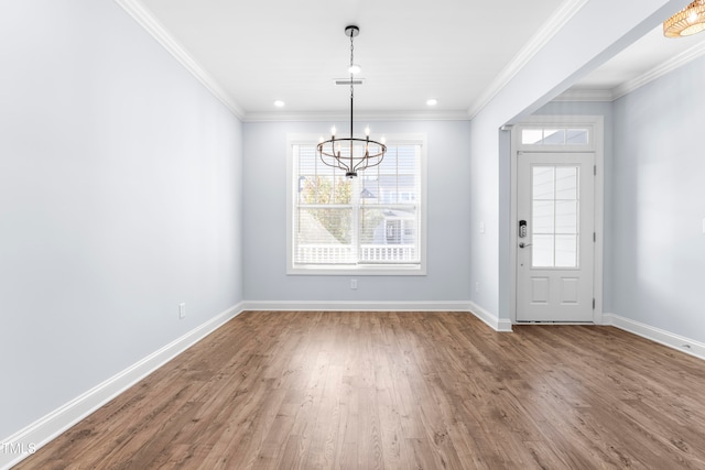 foyer featuring hardwood / wood-style flooring, a notable chandelier, and crown molding