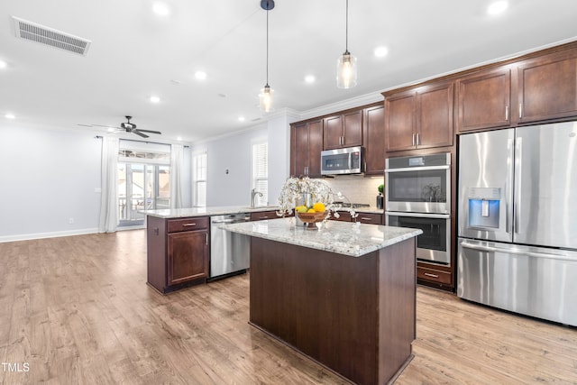 kitchen with kitchen peninsula, appliances with stainless steel finishes, light stone countertops, ceiling fan, and pendant lighting