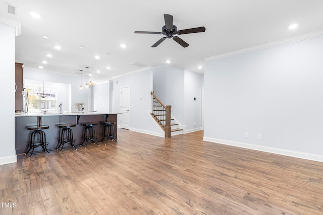 living room featuring crown molding, ceiling fan, and light wood-type flooring