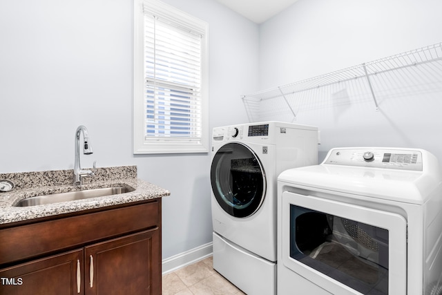 washroom featuring light tile patterned flooring, independent washer and dryer, and sink