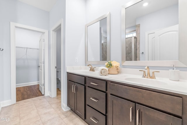 bathroom featuring toilet, tile patterned flooring, vanity, and walk in shower