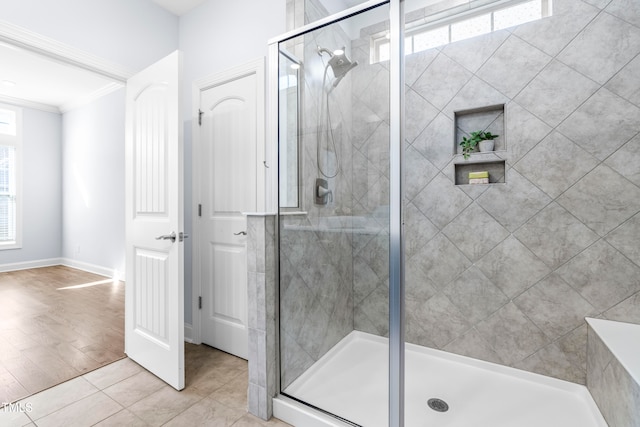 bathroom with tile patterned flooring, a shower with door, and crown molding