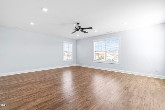 empty room with plenty of natural light, light hardwood / wood-style floors, and ceiling fan