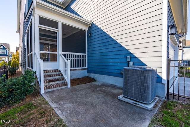 view of exterior entry with cooling unit and a patio area