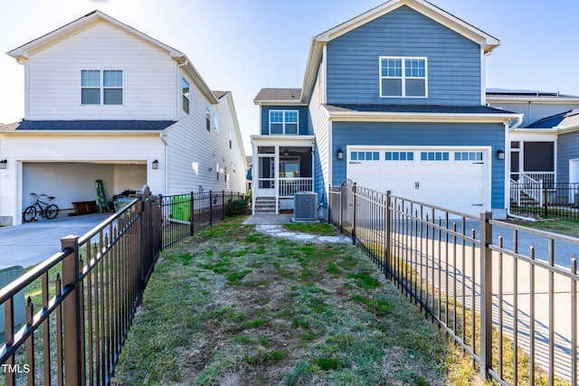 view of front of house featuring central air condition unit, a sunroom, and a garage