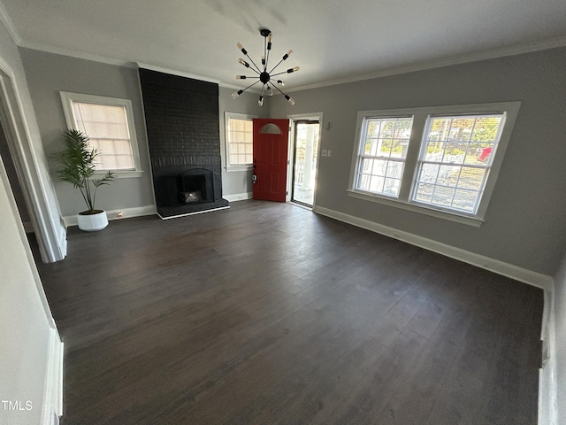 unfurnished living room featuring a notable chandelier, dark hardwood / wood-style floors, ornamental molding, and a fireplace