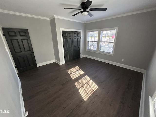 unfurnished bedroom with dark hardwood / wood-style flooring, a closet, ceiling fan, and crown molding