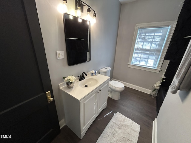 bathroom with wood-type flooring, vanity, and toilet