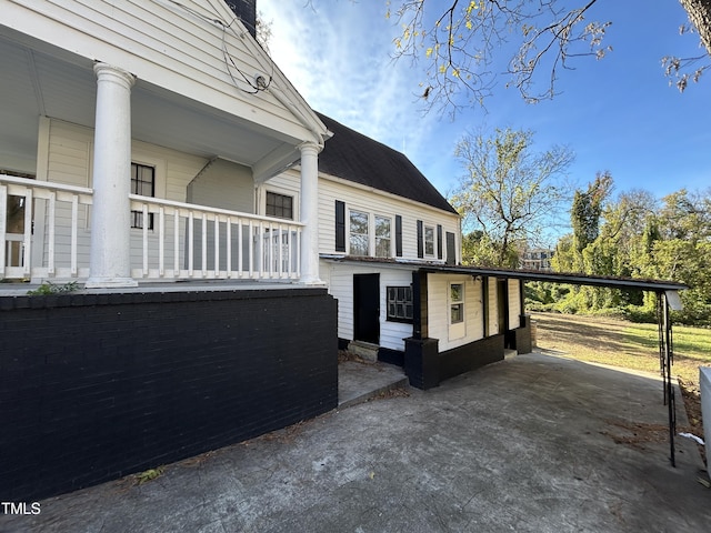 view of home's exterior featuring a porch and a carport