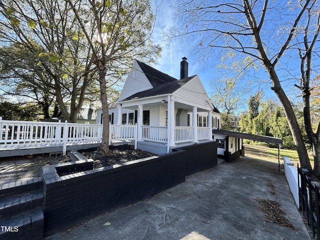 view of side of property featuring covered porch and a carport