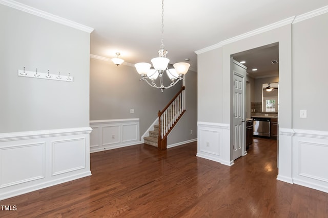 spare room with crown molding, dark wood-type flooring, and ceiling fan with notable chandelier