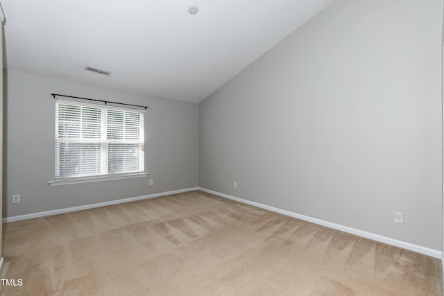 carpeted empty room with vaulted ceiling