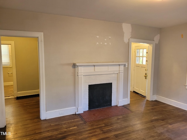 unfurnished living room featuring a fireplace and dark hardwood / wood-style flooring